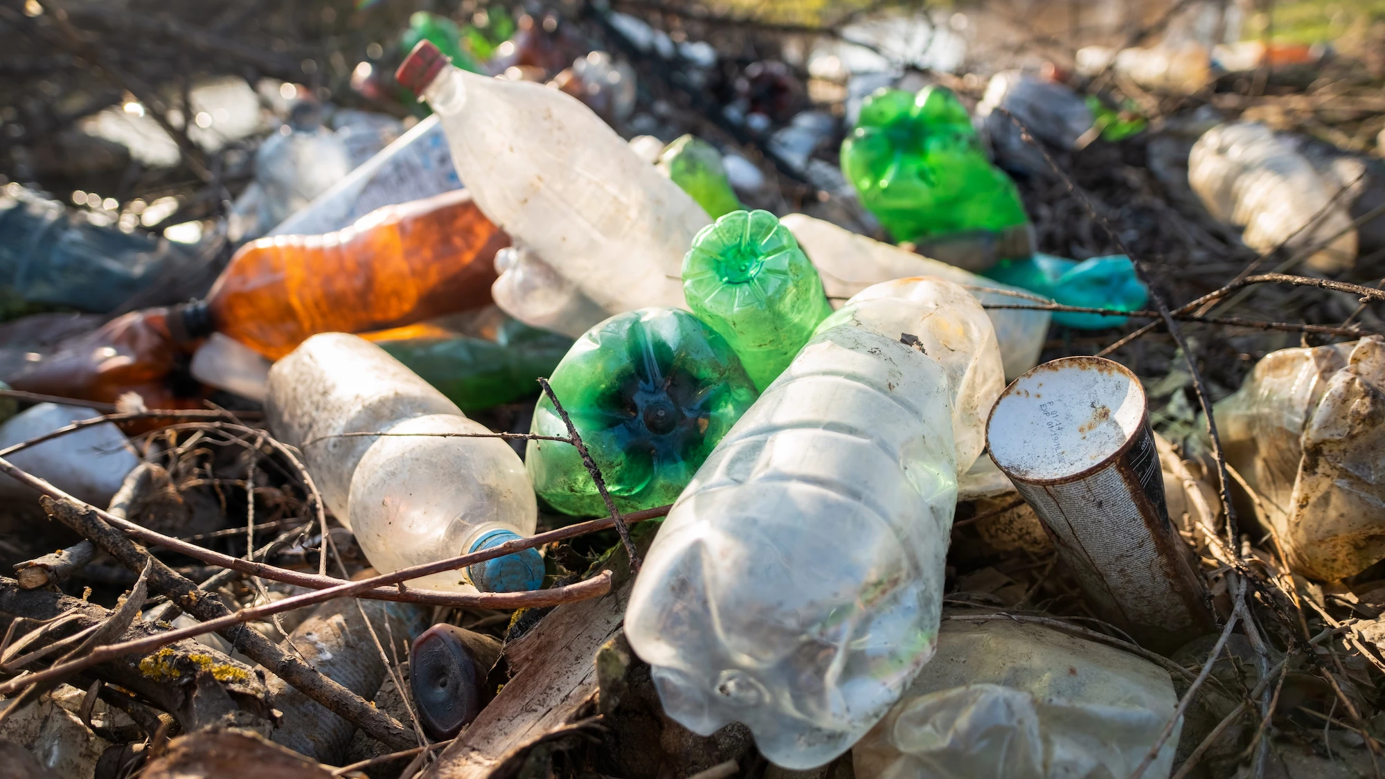 Residuos plásticos flotando en el mar con tonos verdes y tierra, representando la contaminación ambiental