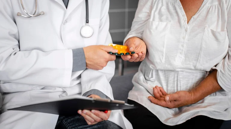 Médico entregando medicamentos a una paciente para explicar por qué el cuerpo humano no responde igual a los tratamientos médicos